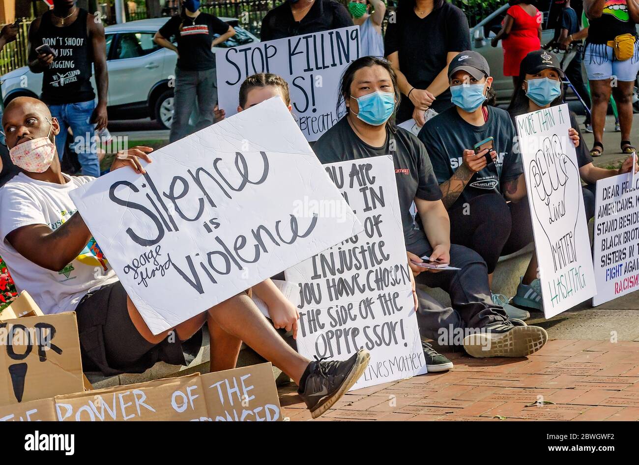 Die Demonstranten halten während einer Mahnwache für George Floyd am Cathedral Square, 31. Mai 2020, in Mobile, Alabama, Zeichen. Stockfoto