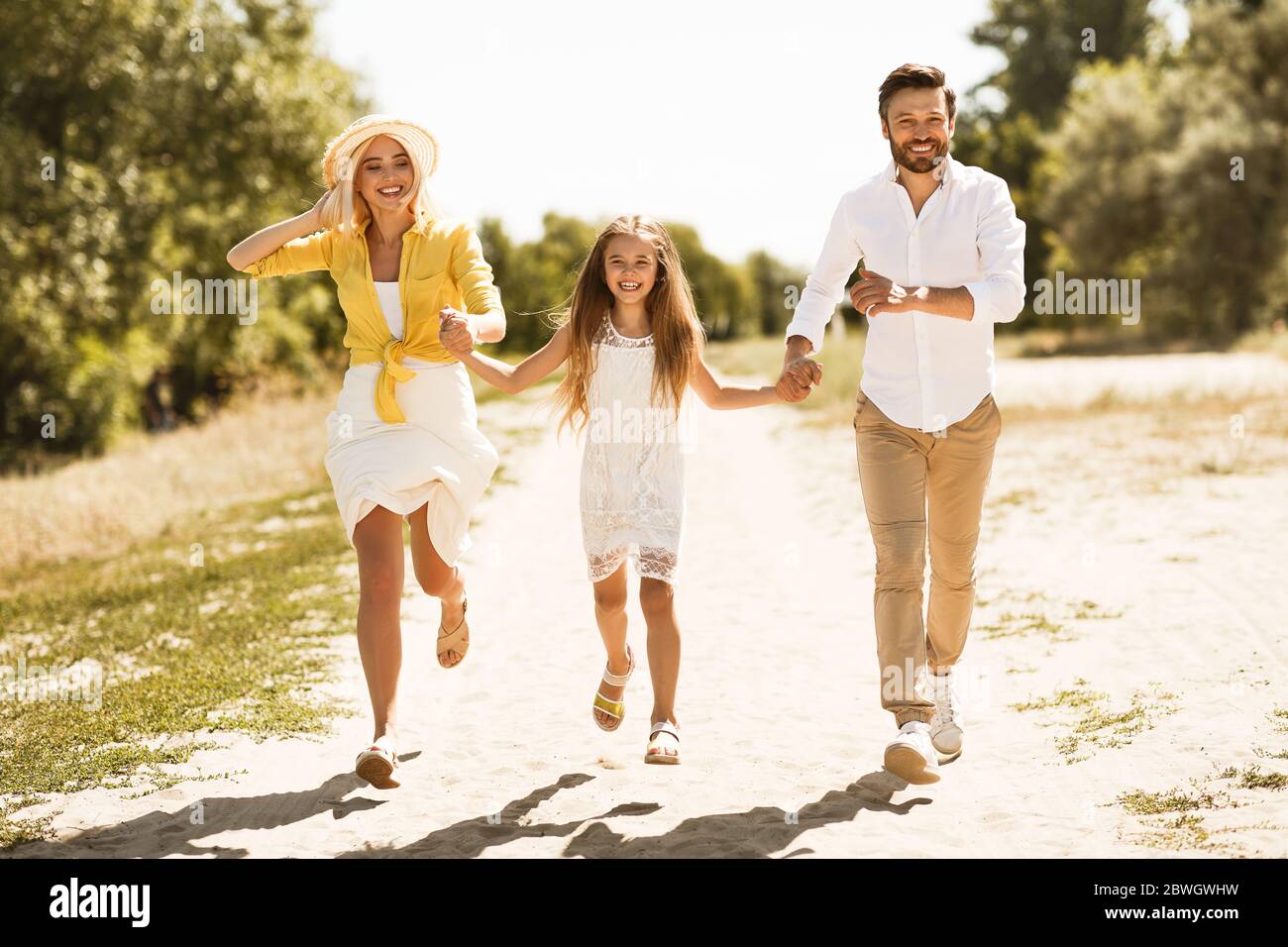 Fröhliche Eltern Und Tochter Walking Hände Im Freien Halten Stockfoto