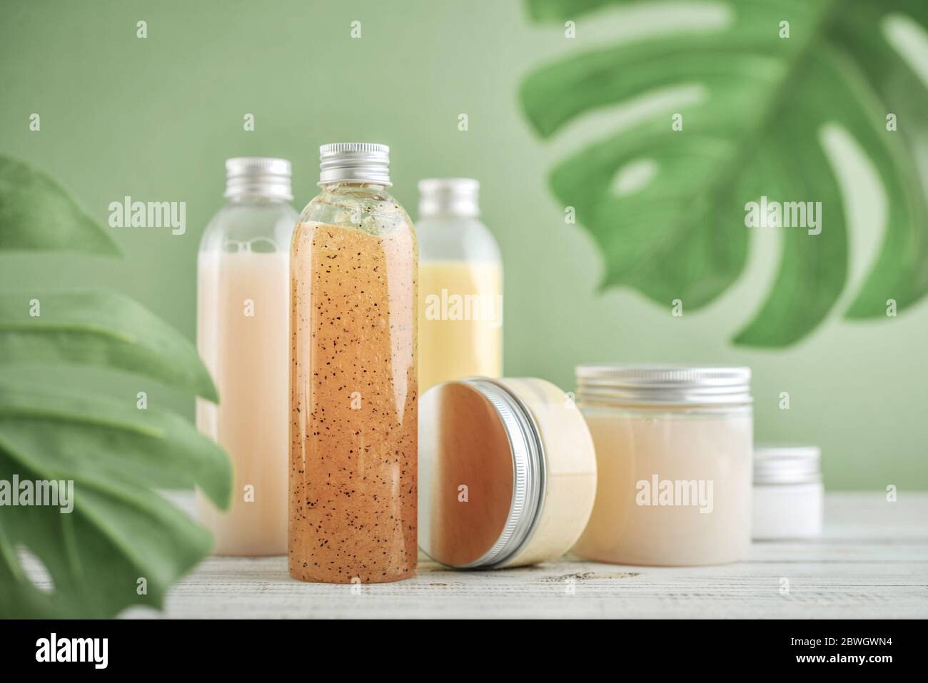 Flaschen mit Spa-Kosmetikprodukten auf grünem Hintergrund Stockfoto