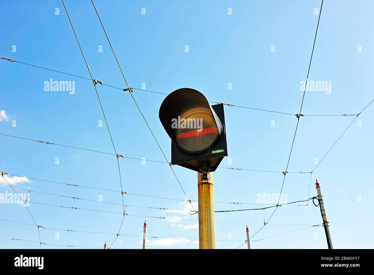 Halten Sie die Fahrbahn an der Ampel gegen die Oberleitungen und den Himmel Stockfoto