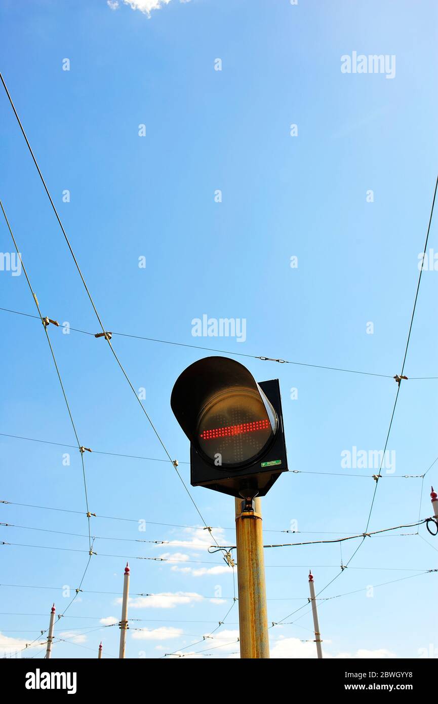 Halten Sie die Fahrbahn an der Ampel gegen die Oberleitungen und den Himmel Stockfoto