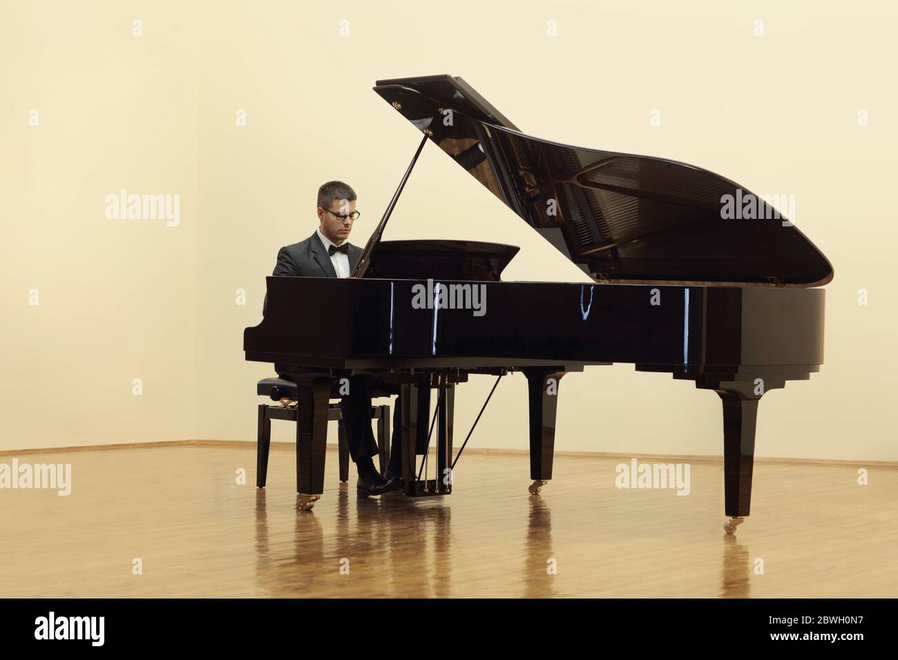 Pianist spielt einen Flügel in einem Salon isoliert auf weißem Hintergrund Stockfoto