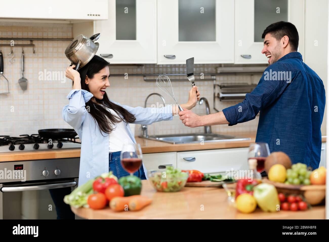 Schönes Paar bereitet Abendessen und kämpft für Spaß Stockfoto