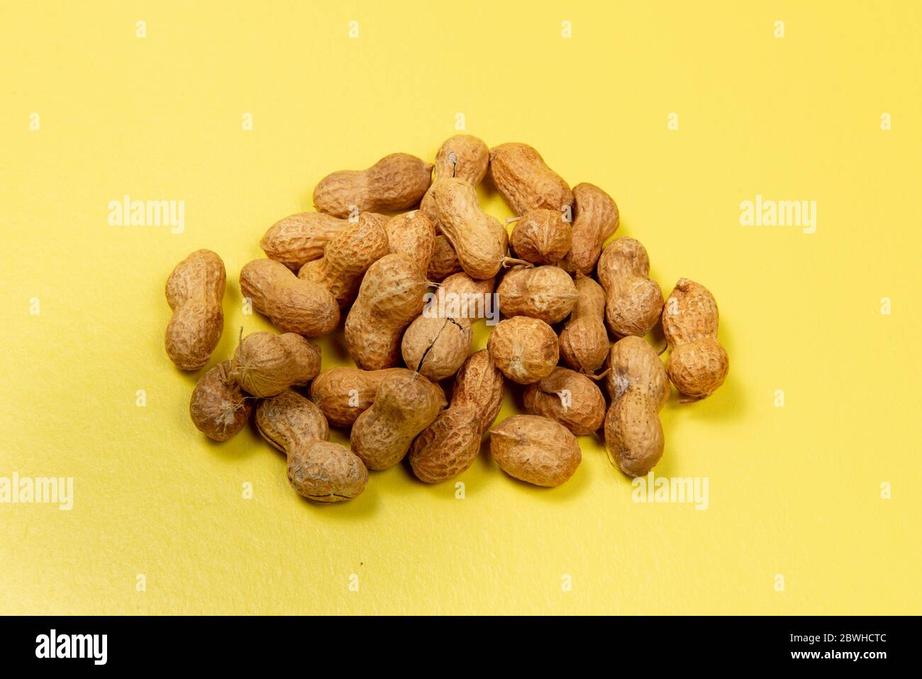 Geschälte Erdnüsse auf gelbem Hintergrund, Ansicht von oben Stockfoto