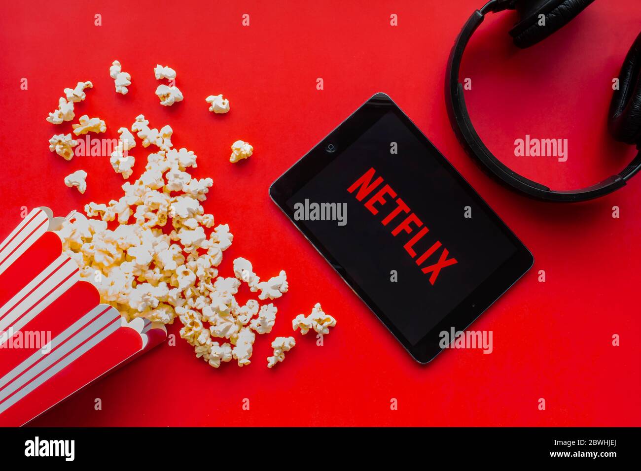 Calgary, Alberta. Kanada. Juni 2020. Ein iPad mit dem Netflix-Logo auf dem Bildschirm auf rotem Hintergrund mit Popcorn und Kopfhörern Stockfoto