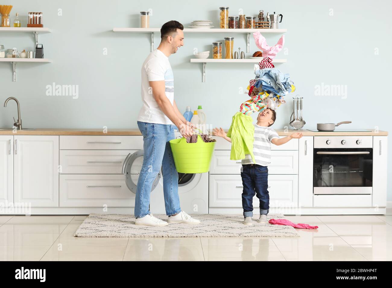Mann und sein kleiner Sohn haben Spaß beim Waschen zu Hause Stockfoto
