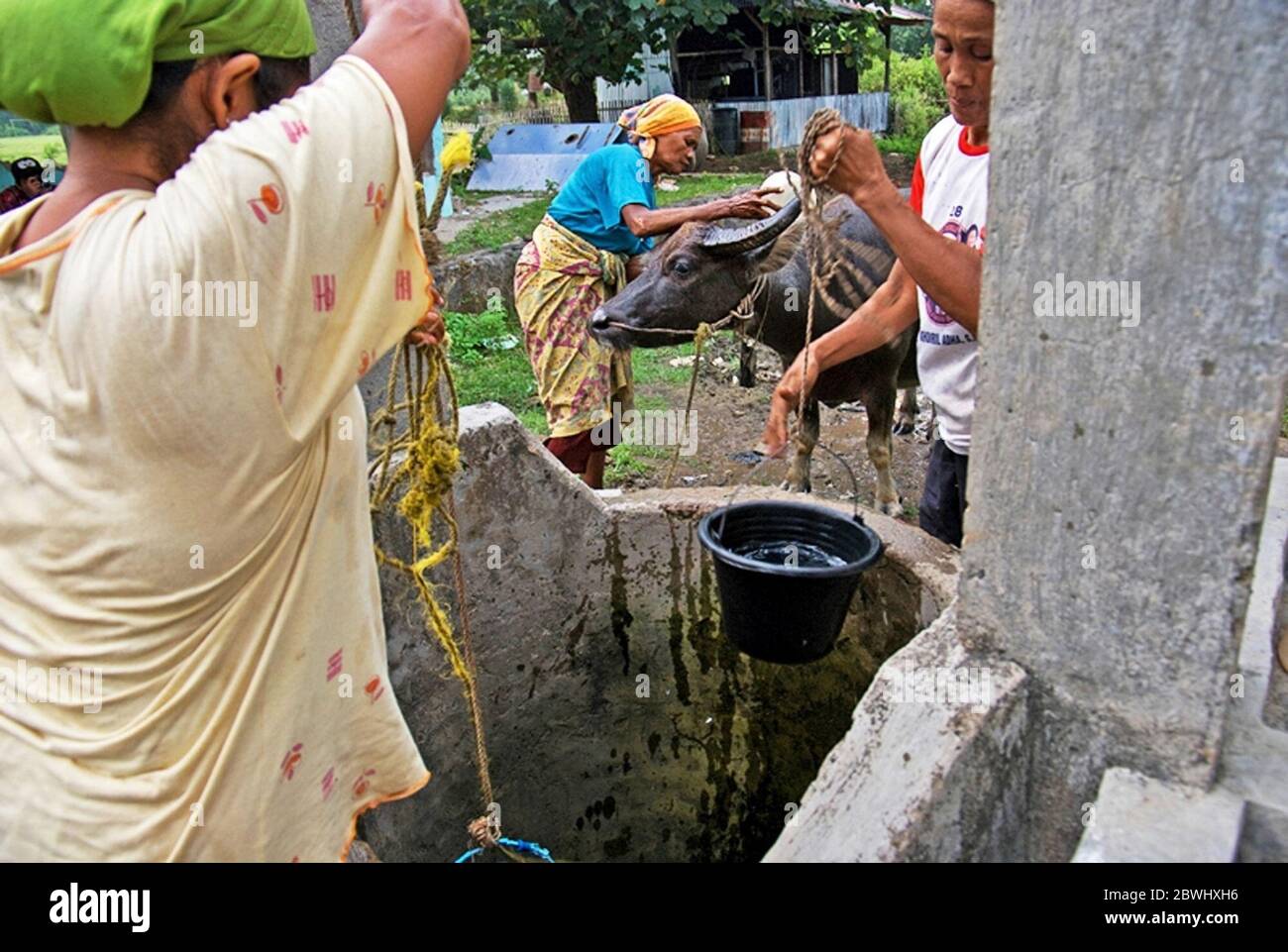 Frauen, die Wasser aus einem Gemeinschaftsbrunnen auf der Insel Sebesi nehmen, einer abgelegenen Insel in der Sundastraße, die administrativ innerhalb der Regentschaft South Lampung, Provinz Lampung, Indonesien liegt. © Reynold Sumayku Stockfoto