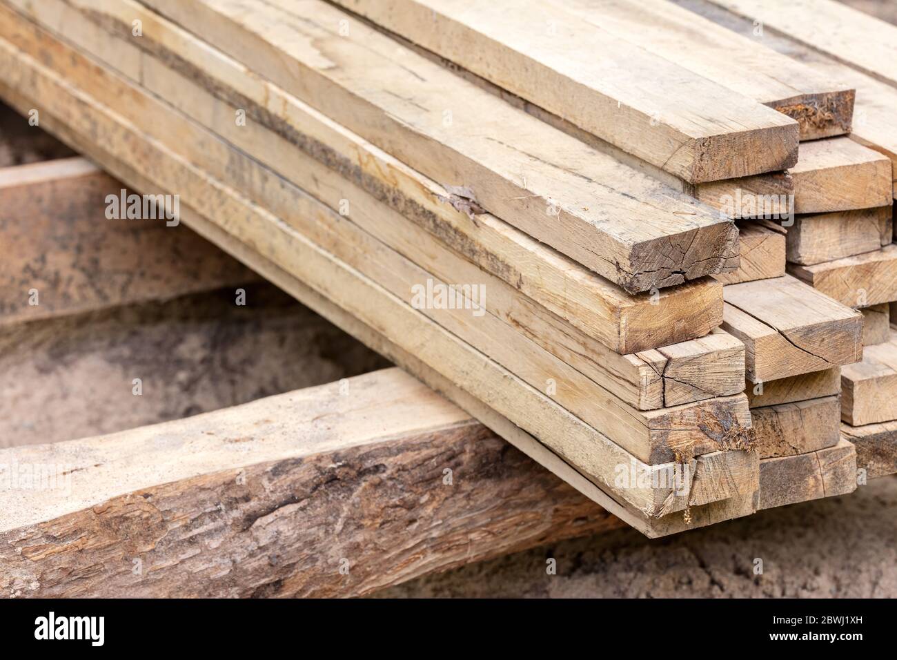 Stapel von natürlichen braunen rauen Holzbrettern auf der Baustelle. Gestapelte Holzbretter. Stockfoto
