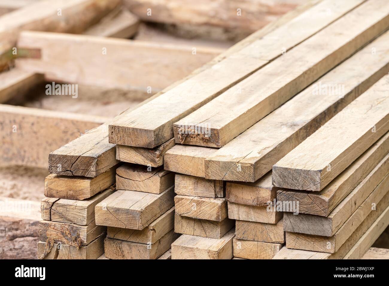 Holzstapel von natürlichen rauhen Holzbrettern auf der Baustelle. Material für den Bau. Stockfoto