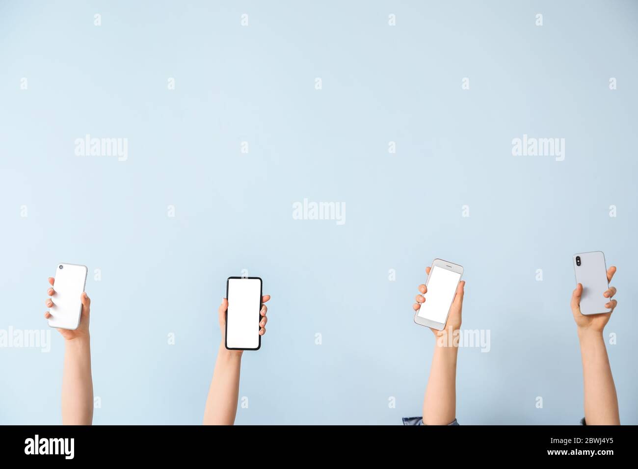 Weibliche Hände mit Mobiltelefonen auf hellem Hintergrund Stockfoto