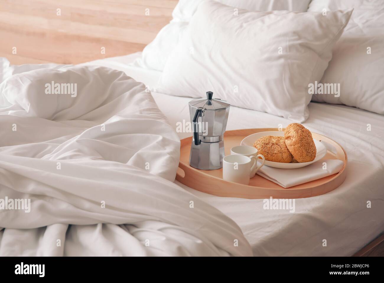 Tablett mit Frühstück auf einem großen Bett Stockfoto
