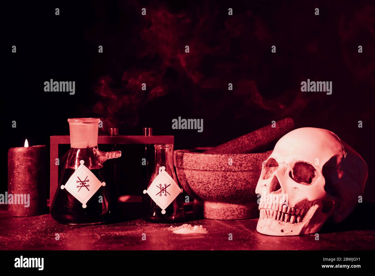 Tränke, menschlicher Schädel, Mörser und Stößel auf dem Tisch des Alchemisten Stockfoto