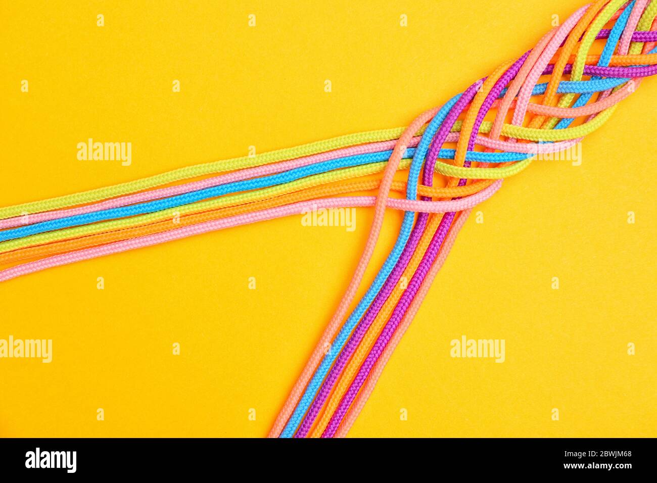 Geflochtene Seile auf farbigem Hintergrund. Einheitlichkeit Stockfoto