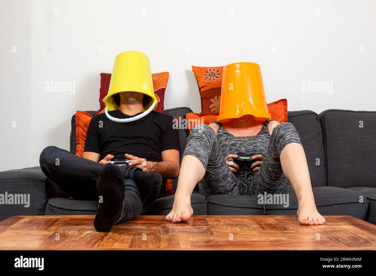 Junges Paar spielen Videospiele bequem auf dem Sofa zu Hause sitzen. Sie trinken Bier und essen Chips Stockfoto