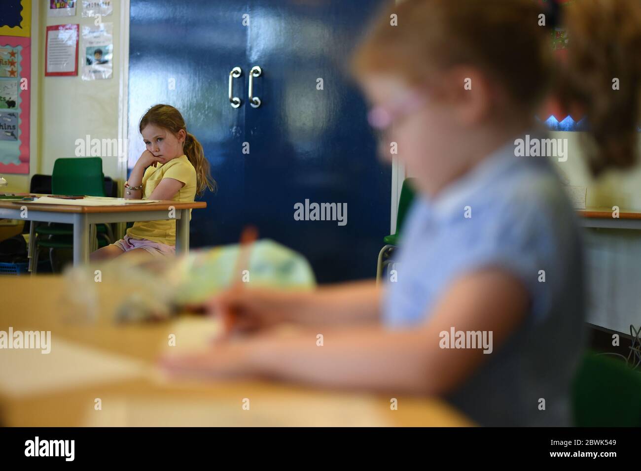 Die Schüler sitzen an separaten Schreibtischen in der Hiltingbury Infant School in Chandler's Ford, Hampshire, als Schüler in Empfang, Jahr 1 und Jahr 6, beginnen, zur Schule als Teil einer breiteren Lockdown Maßnahmen in England wieder zurückzukehren. Stockfoto