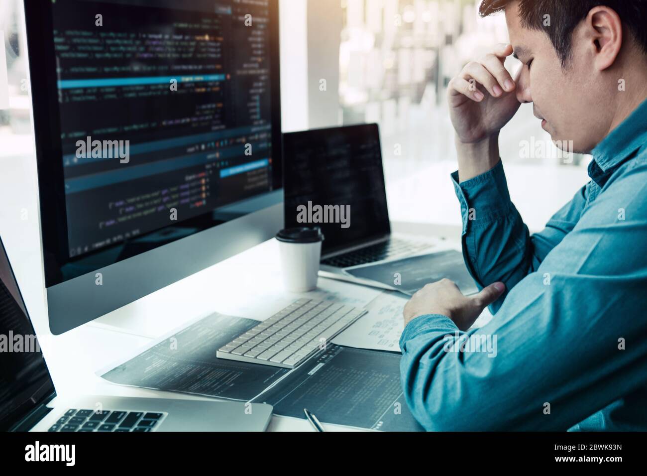 Softwareentwickler haben im Büro Kopfschmerzen bei der Codeanalyse. Stockfoto