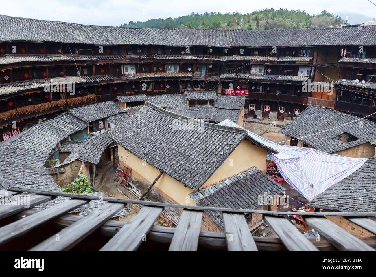 Innenansicht eines Fujian Tulou mit vier Etagen und kleineren Gebäuden im Inneren. Stockfoto