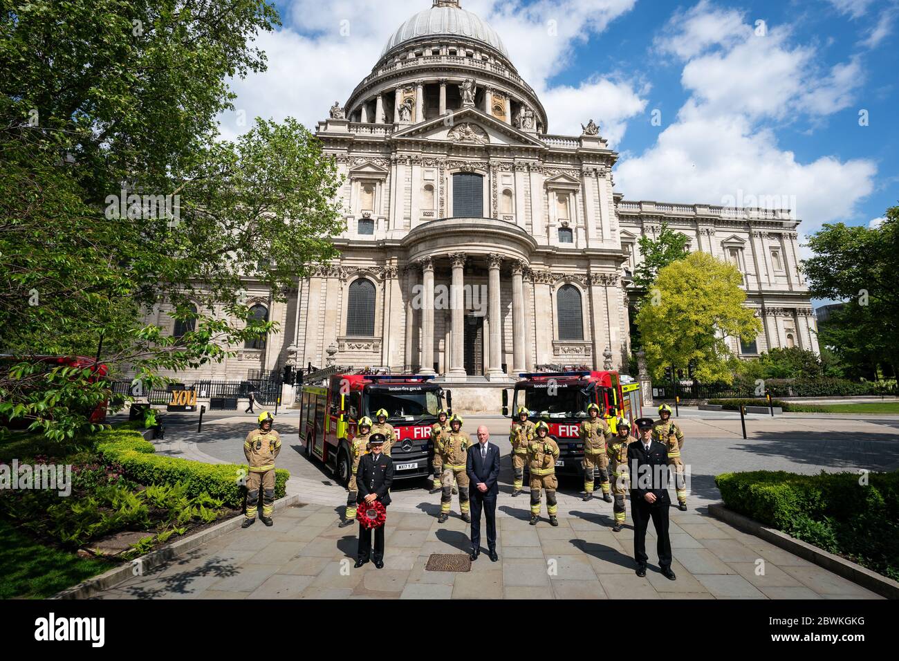 Mitglieder der London Fire Brigade am National Firefighters' Memorial in St. Pauls, London, in Erinnerung an die Feuerwehrleute, die ihr Leben in der Dienstlinie verloren haben. Stockfoto