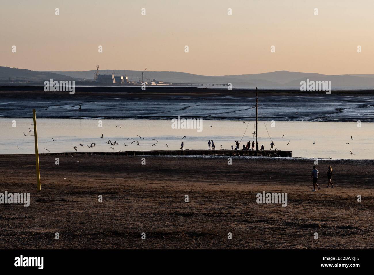 Burnham-on-Sea, England, Großbritannien - 31. Mai 2020: Menschen fischen, spazieren, joggen und spielen am Strand und in den Schlammwohnungen an der Mündung des Flusses Parrett in Burnham-on Stockfoto