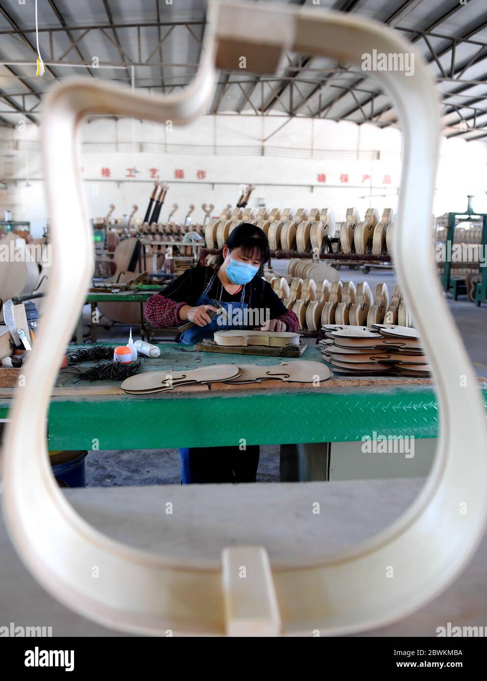 Hengshui, Chinas Provinz Hebei. Juni 2020. Ein Arbeiter montiert Musikinstrumente in einer Musikinstrumentenfabrik im Wuqiang Bezirk von Hengshui, Nordchinesische Provinz Hebei, 2. Juni 2020. Die Behörden im Wuqiang County haben eine Initiative zur Armutsbekämpfung durchgeführt, die die lokale Musikinstrumentenindustrie dazu ermutigt, ländliche Bewohner, die unterhalb der aktuellen Armutsgrenze leben, einzustellen und ihnen dabei zu helfen, neue Karrieren zu beginnen. Kredit: Zhu Xudong/Xinhua/Alamy Live News Stockfoto