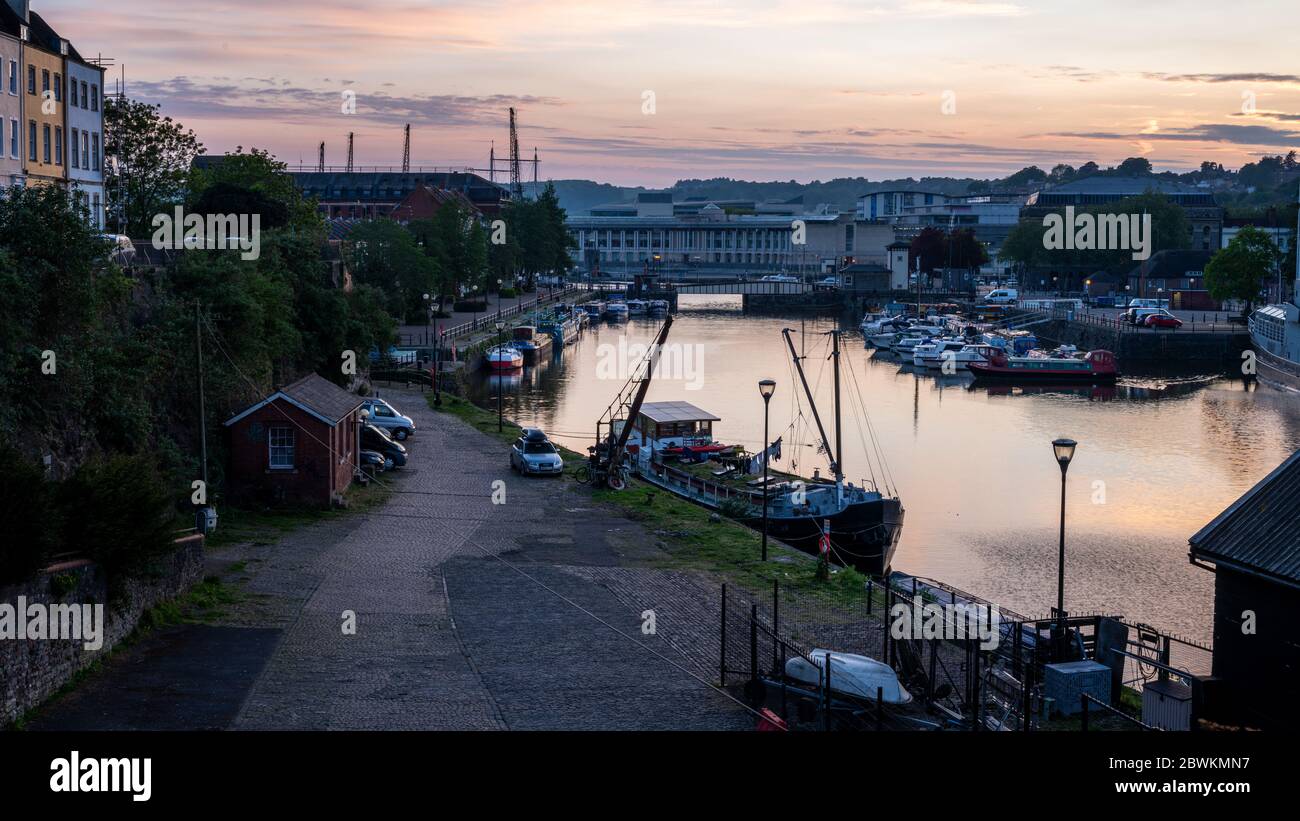 Bristol, England, UK - 11. April 2020: Die Sonne untergeht über dem schwimmenden Hafen von Bristol und Hausboote liegen am Redcliffe Quay und Mud Dock, als viewe Stockfoto