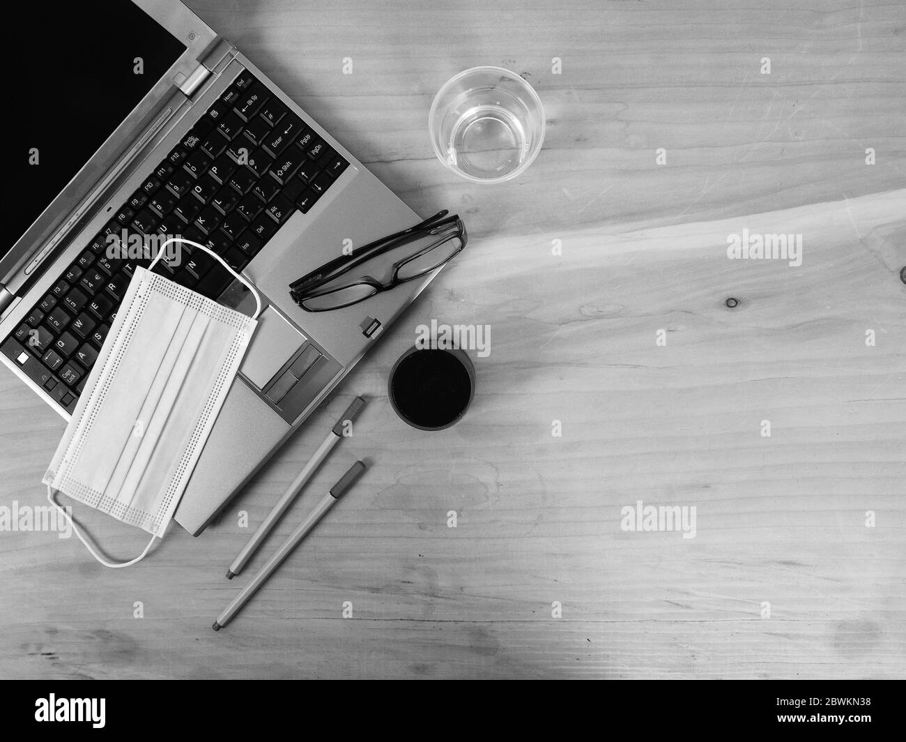 Arbeitsplatz zu Hause für Remote-Arbeit - Smart Working in neuen Alltag mit lsilver Laptop auf Holztisch und Gesichtsmaske - Lösung gegen Verbreitung von Stockfoto
