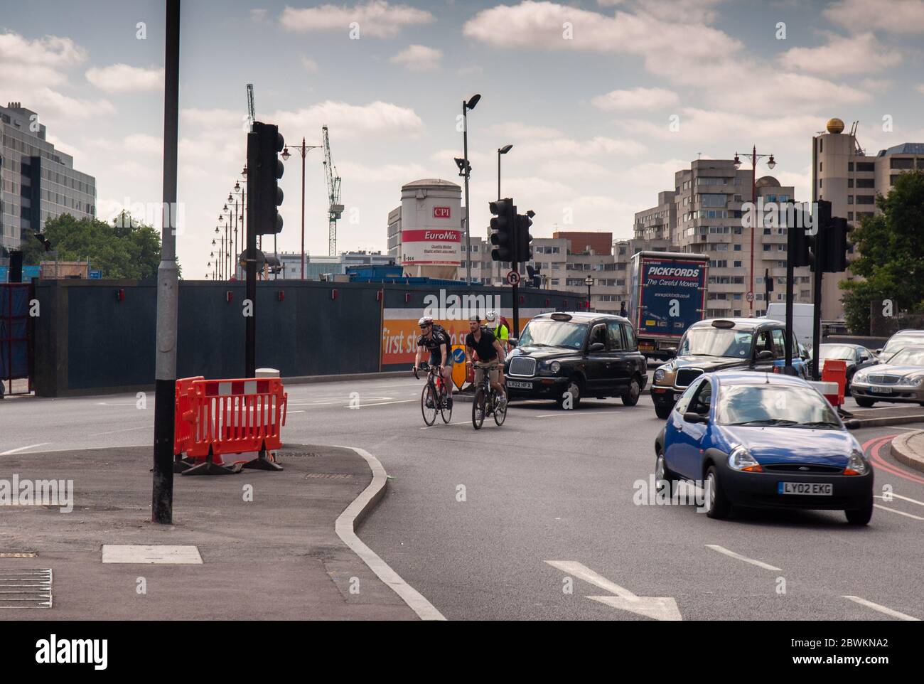 London, England, Großbritannien - 30. Juli 2011: Radfahrer und Autoverkehr passieren die Kreuzung von Blackfriars Bridge und Queen Victoria Street während der Fahrzeit Stockfoto