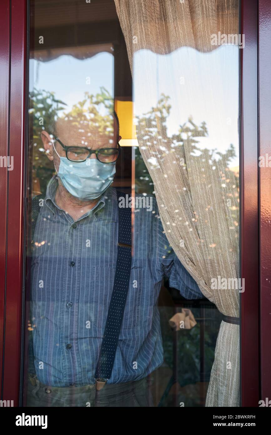 MADRID, SPANIEN - 28. MAI 2O2O: Ein alter Mann, der von COVID-19 eingesperrt wurde, schaut vom Fenster seines Hauses aus auf die Straße Stockfoto