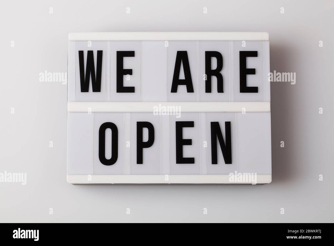 Leuchtkasten mit Text sind wir auf weißem Hintergrund offen, nach covid-19 Shutdown Konzept wieder zu öffnen Stockfoto
