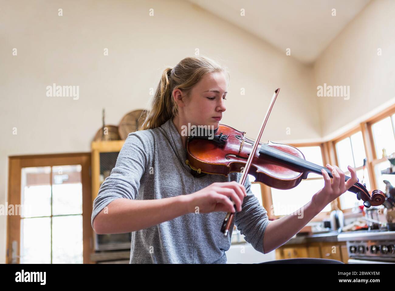 13-jähriges Mädchen spielt Geige zu Hause Stockfoto