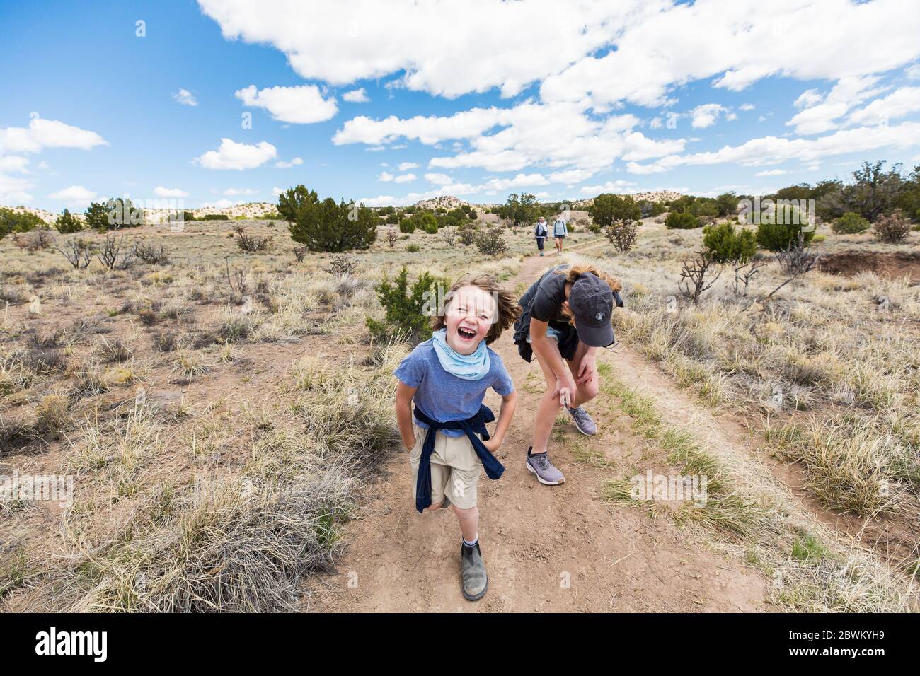 6 Jahre alter Junge läuft auf Wanderwegen mit älterer Schwester, Galisteo Basin, NM. Stockfoto