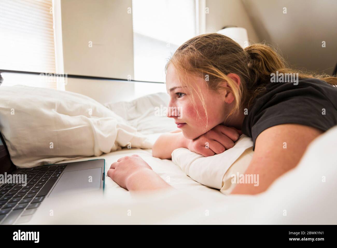 Teen Alter Mädchen suchen Laptop im Bett Stockfoto