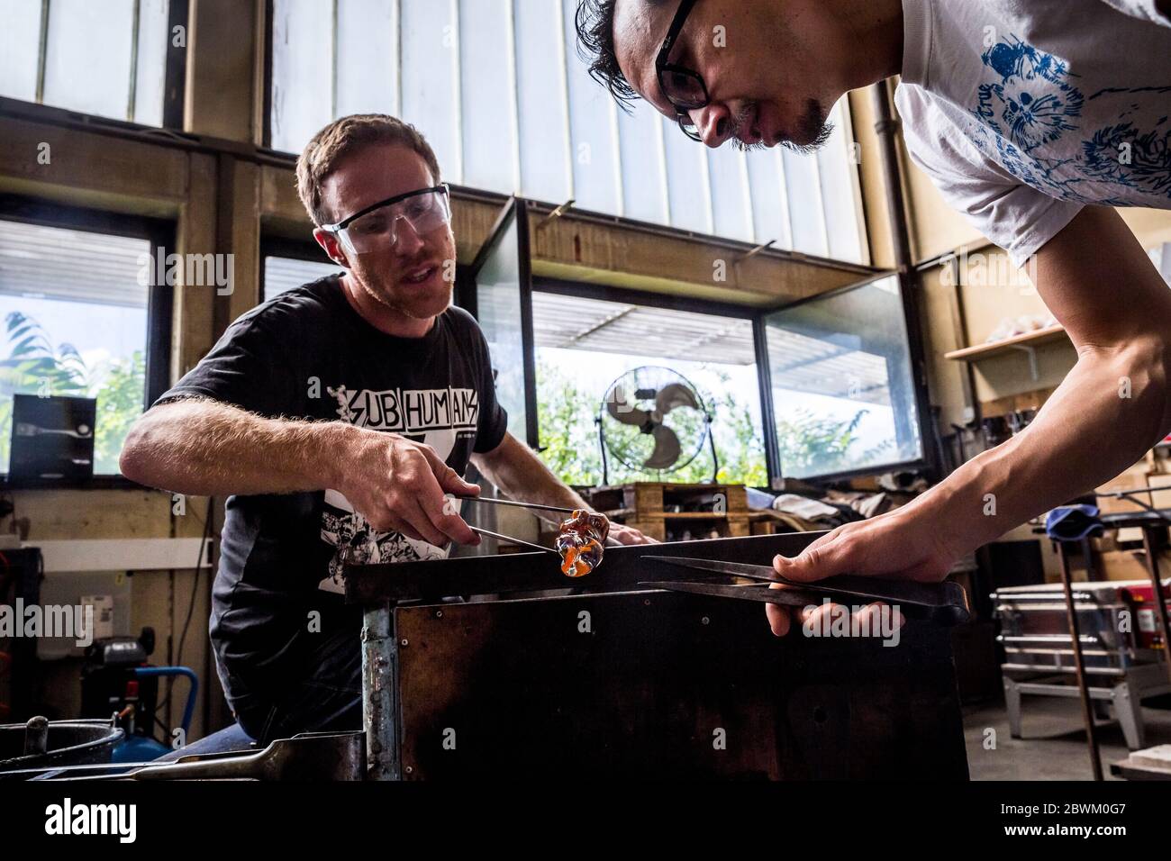 Ein Schüler erhält Unterricht während einer Glasbläserstunde in der Berliner Glas-Werkstatt in Wedding, Berlin, Deutschland Stockfoto
