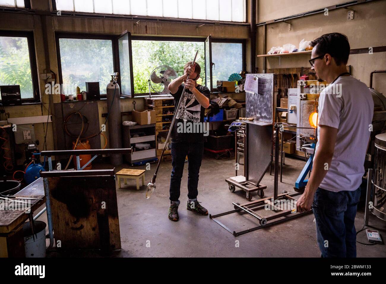 Ein Schüler erhält Unterricht während einer Glasbläserstunde in der Berliner Glas-Werkstatt in Wedding, Berlin, Deutschland Stockfoto