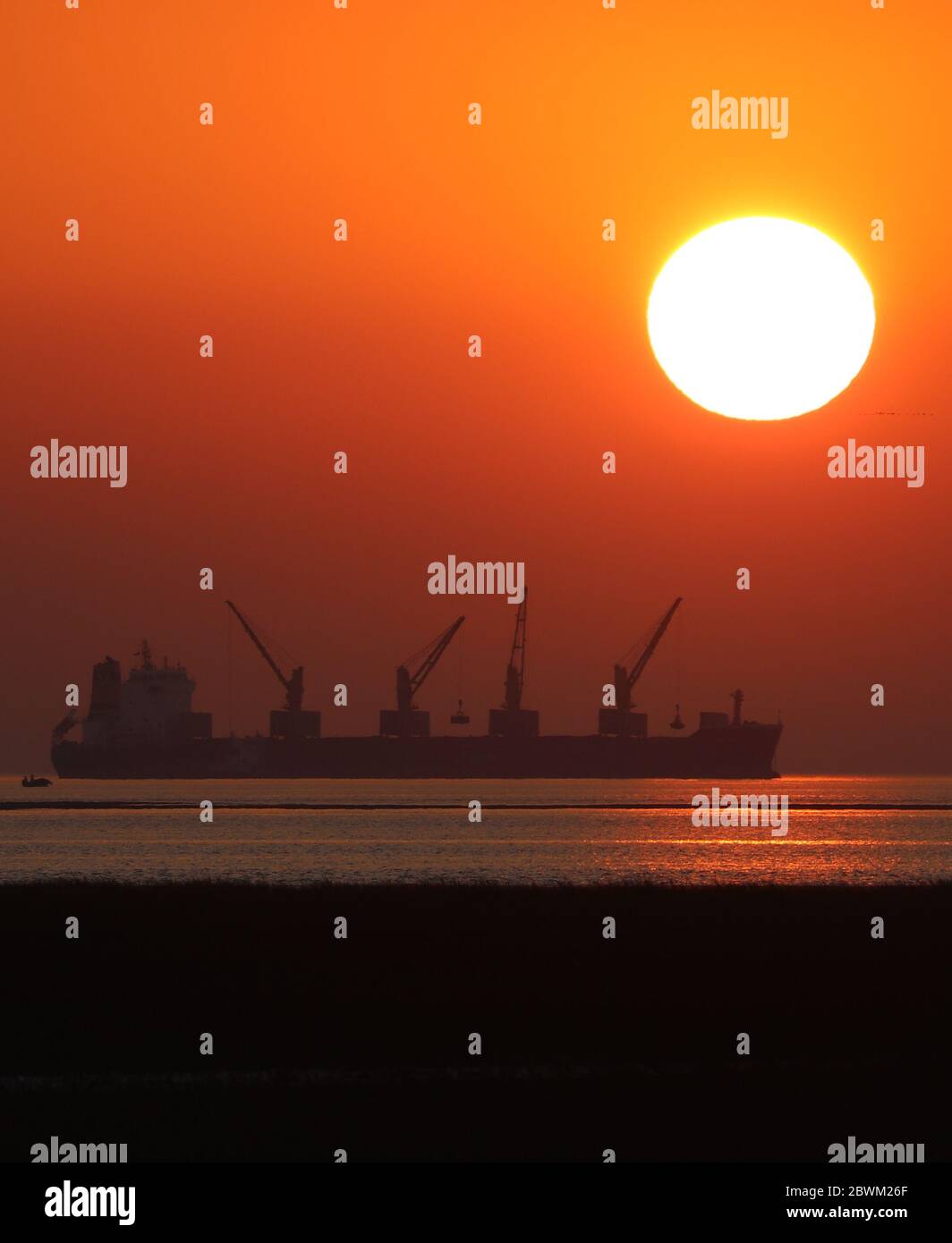 Der Sonnenuntergang auf einer Küste mit einem Schiff. Selektiver Fokus. Geringe Schärfentiefe. Hintergrundunschärfe. Stockfoto