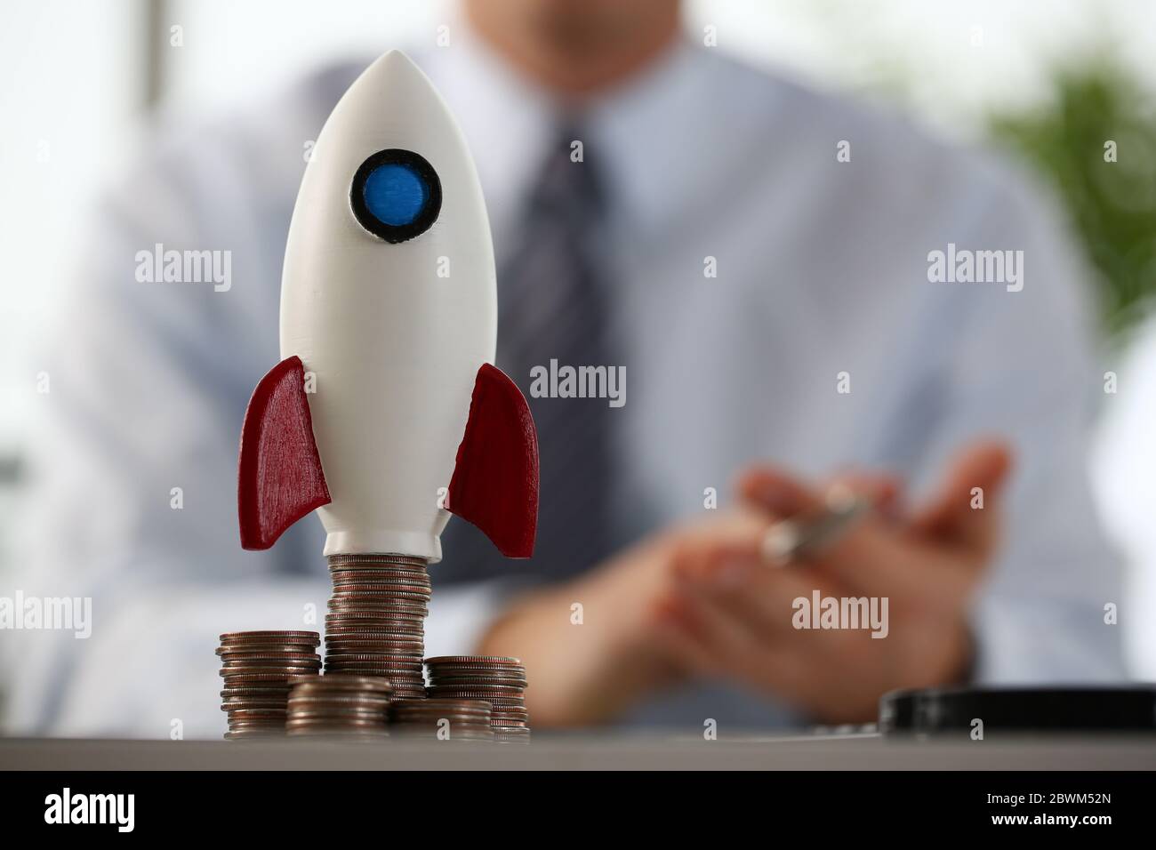 Makro-Foto auf kleine Rakete, die auf Münzen stehen Stockfoto