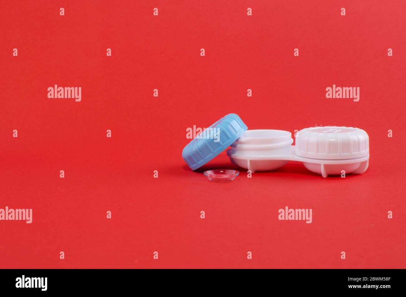 Objektivtasche und ein Objektiv auf rotem Hintergrund. Stockfoto