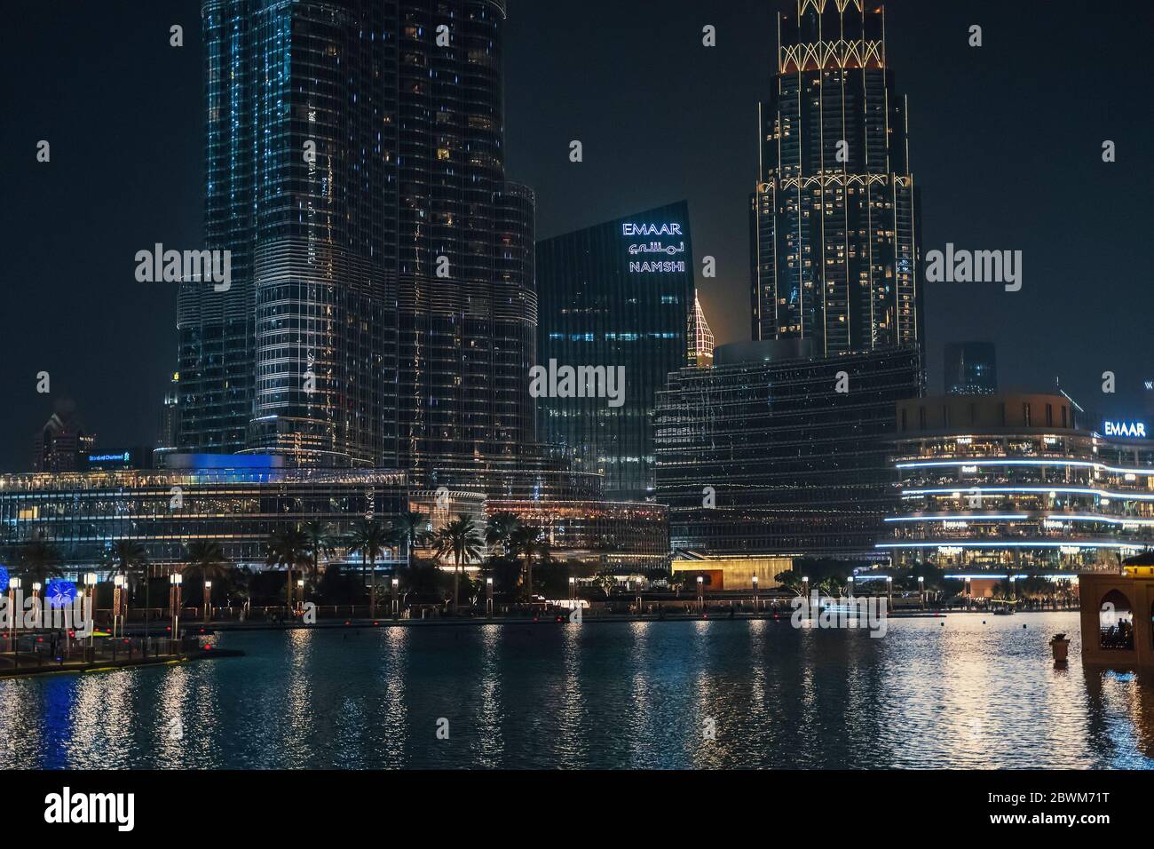 Dubai, VAE - Februar 2020 : Pool mit Reflexion und beleuchteten hohen Burj-Khalifa und Dubai Mall Gebäude in der Nacht, VAE. Stockfoto