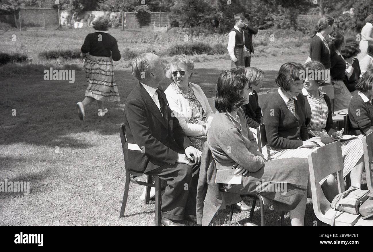 1950er Jahre, historisch, Sommerzeit und eine Schule sporttag, Eltern, Mitschüler und Lehrer sitzen neben der Grass-Bahn, die Veranstaltung zu beobachten, England, Großbritannien. Stockfoto