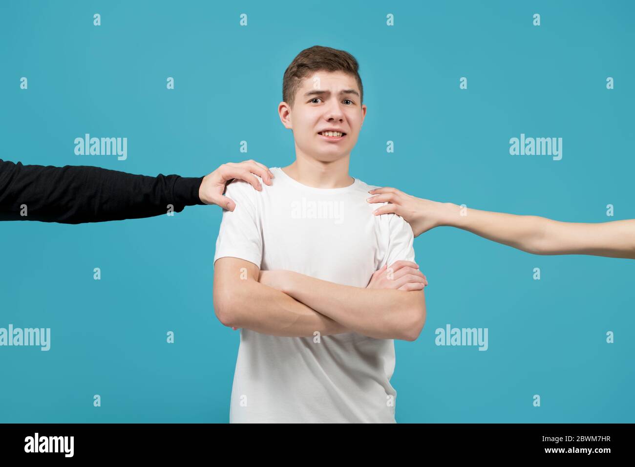 Hände auf den Schultern eines jungen Mannes, der ist Überrascht und verängstigt Stockfoto