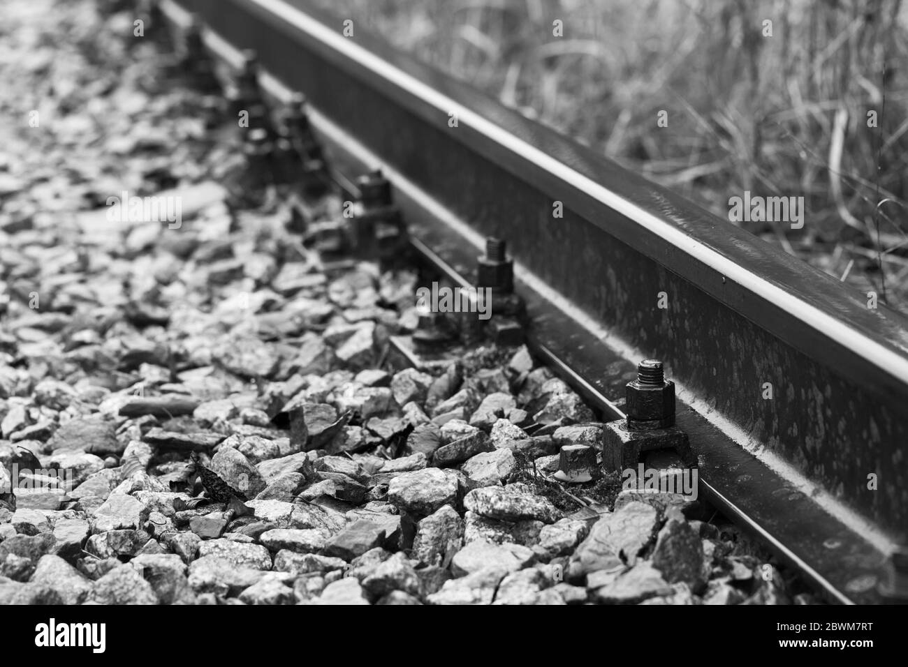Details der Bahnstrecke, Nahaufnahme in Schwarzweiß mit selektivem Fokus und perspektivem Effekt Stockfoto