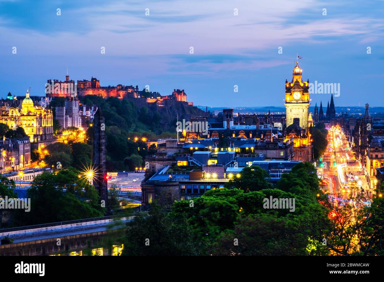 Edinburgh, Großbritannien. Luftaufnahme von Calton Hill in Edinburgh, Schottland. Die Stadt mit beleuchteten Schloss und Uhrturm in der Nacht. Wolkiger Himmel bei Sonnenuntergang Stockfoto