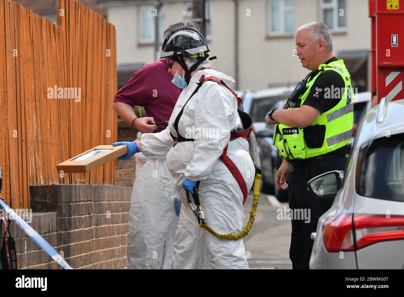 Ein Tatort eines Kriminalbeamten stellt einen Beweiskasten an einer Wand vor einem Haus in der Wessex Road in Salisbury, Wiltshire, wo zwei Frauen nach einer Störung am Montag starben. Ein Mann in den 30er Jahren wurde wegen Mordes verhaftet und in der Melksham Polizeistation in Gewahrsam genommen. Stockfoto