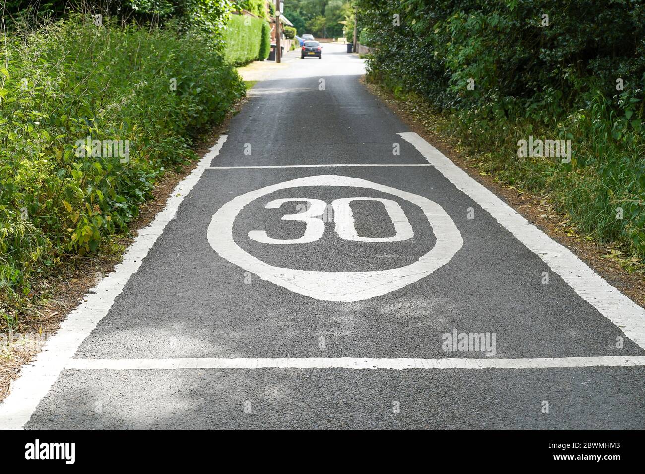 Nahaufnahme von 30 mph Geschwindigkeitsbegrenzung Straßenmarkierungen auf ländlichen Landstraße gemalt, UK Landschaft. Kennzeichnungen zur Geschwindigkeitsbegrenzung. Stockfoto
