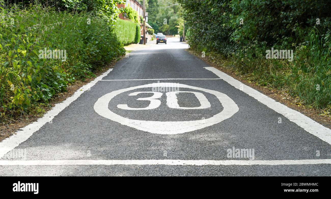 Nahaufnahme von 30 mph Geschwindigkeitsbegrenzung Straßenmarkierungen auf ländlichen Landstraße gemalt, UK Landschaft. Kennzeichnungen zur Geschwindigkeitsbegrenzung. Stockfoto