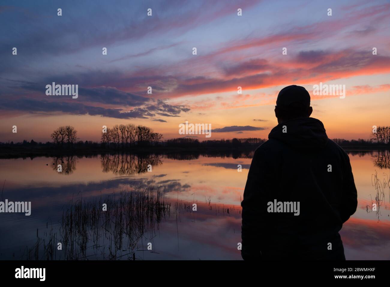 Mann am See, Blick auf die Wolken nach Sonnenuntergang, Abendansicht Stockfoto