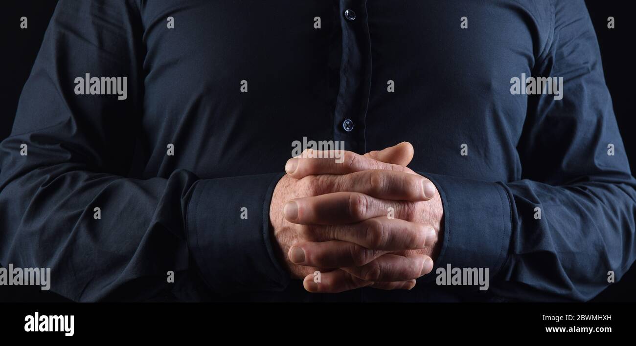hombre con los dedos entrelazados con camisa Stockfoto