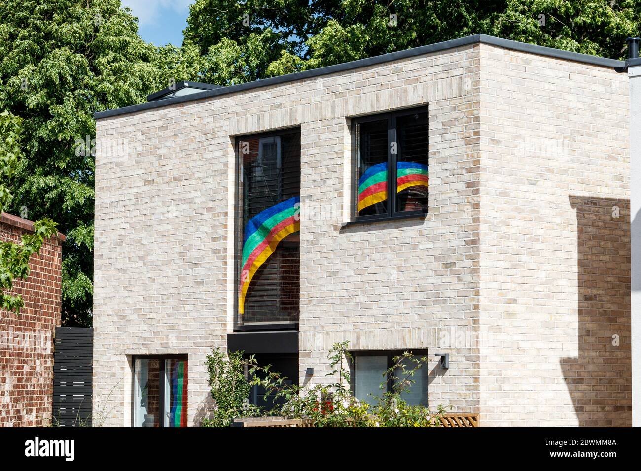Ein modernes Haus mit einem bemalten Regenbogen in seinen Fenstern zur Unterstützung der wichtigsten Arbeitnehmer während der Coronavirus Gesundheitskrise, North London, Großbritannien Stockfoto