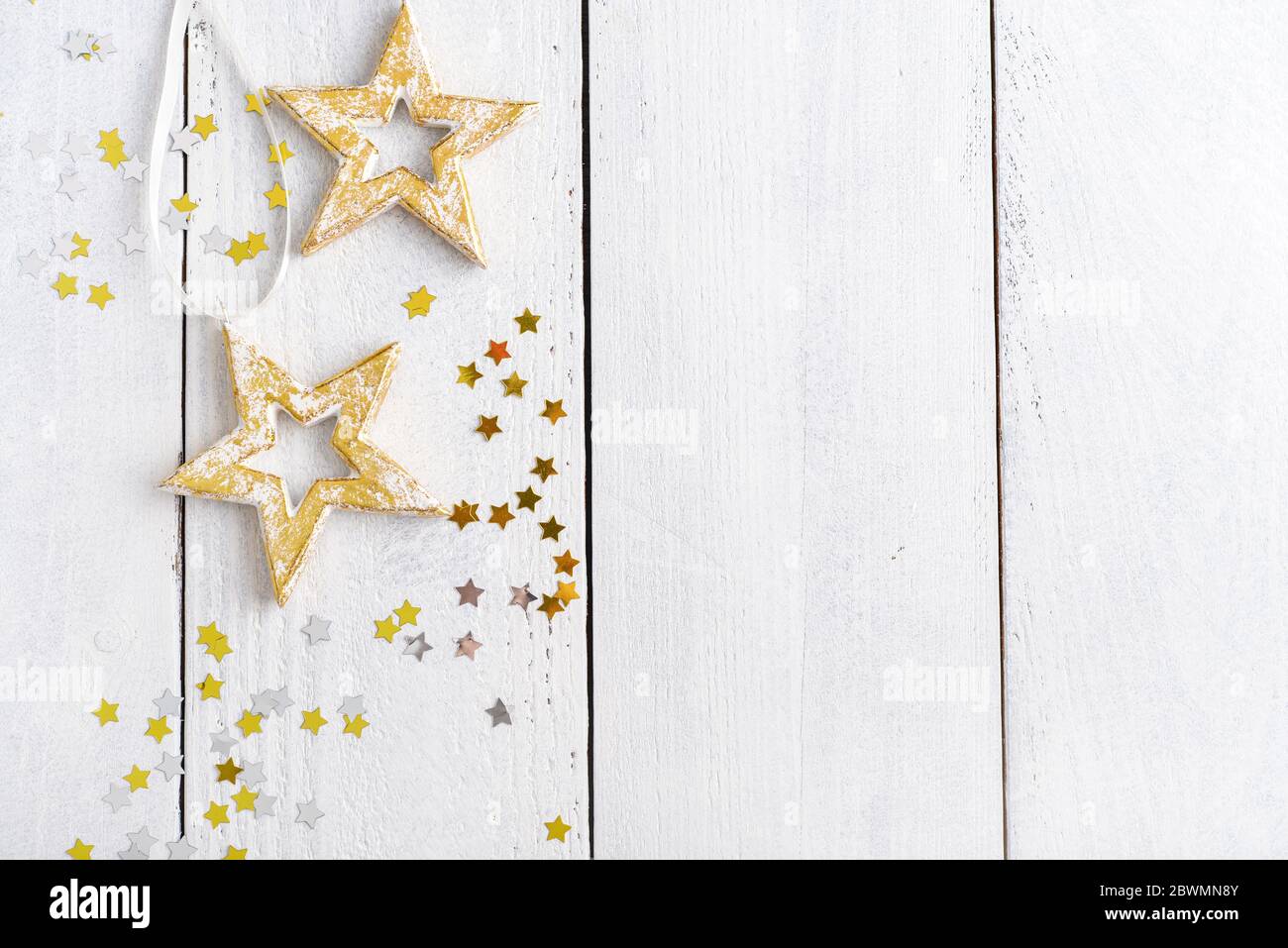 Weihnachtsschmuck in Form von Sternen auf weißem Holzhintergrund, Draufsicht Stockfoto