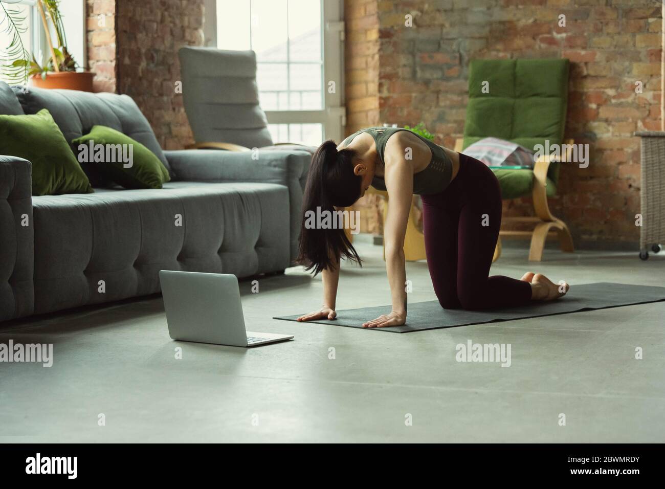 Balance. Sportlich schöne junge Frau, die professionelle Yoga-Unterricht online und üben zu Hause. Konzept des gesunden Lebensstils, Wellness, Wohlbefinden, auf der Suche nach neuen Hobby. Flexibel und motiviert. Stockfoto